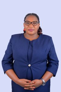 Official portrait of the Head Teacher of St. John's S.S - Ikumba, dressed in a professional blue suit.
